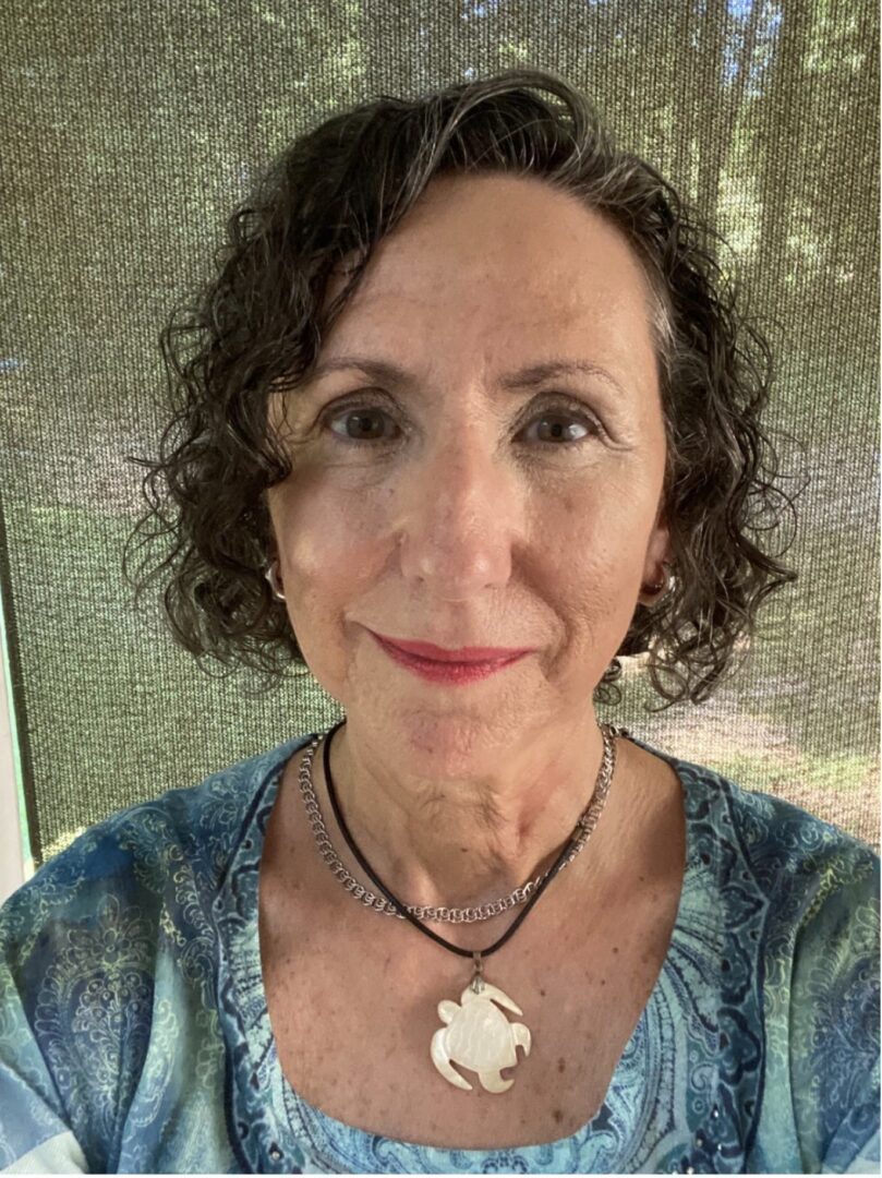A woman with curly hair wearing a necklace.