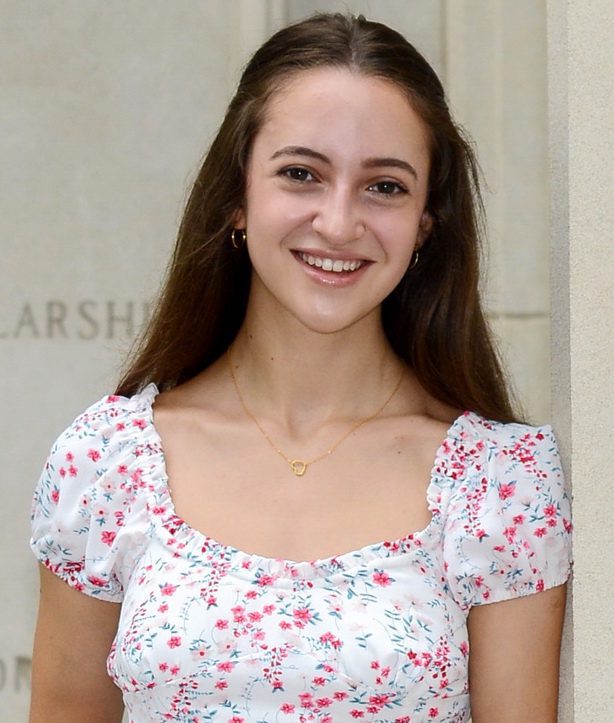 A young woman in floral dress smiling for the camera.